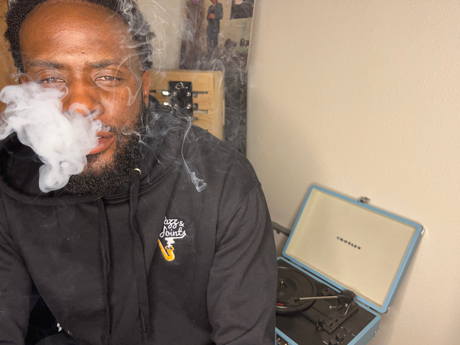 Jazz & Joints host in the original embroidered hoodie beside a record player